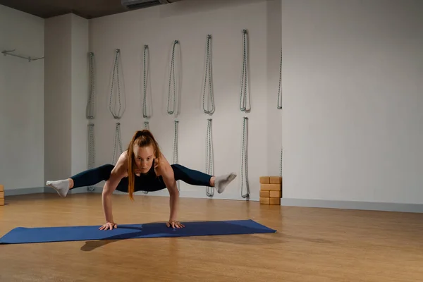 Athletic woman doing pilates yoga stretching for health in the studio. Athletic body girl.