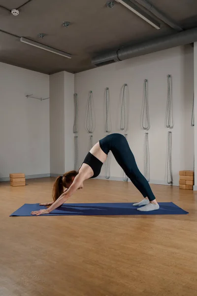 Athletic woman doing pilates yoga stretching for health in the studio. Athletic body girl.
