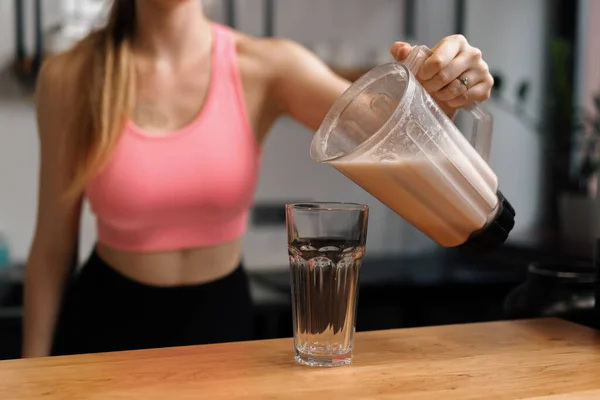 Curvy women make a protein shake at the fitness health bar in gym