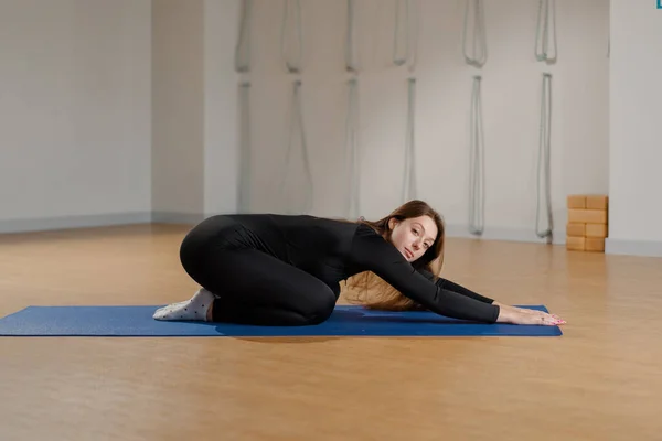 Athletic woman doing pilates yoga stretching for health in studio. Athletic body girl.