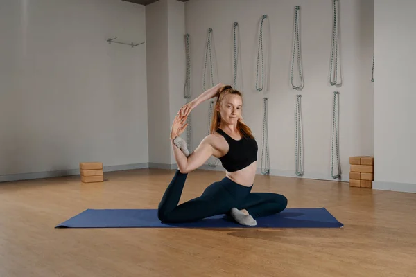Athletic woman doing pilates yoga stretching for health in studio. Athletic body girl.
