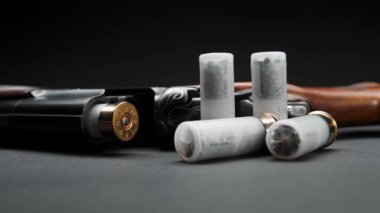 Close-up of a loaded shotgun and ammo on table in smoke
