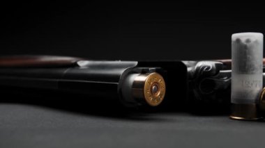 Close-up of a loaded shotgun and ammo on table