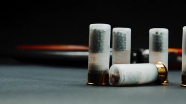 Close-up shotgun shells and a shotgun on a dark background