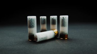 Close-up shotgun shell in smoke against a dark background