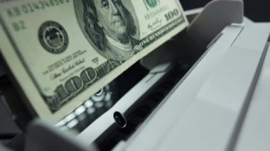Money counting equipment for paper money calculation. Automatic mechanism bank financial operations. Currency exchange of one hundred usd. Closeup currency counting machine counting dollar bills