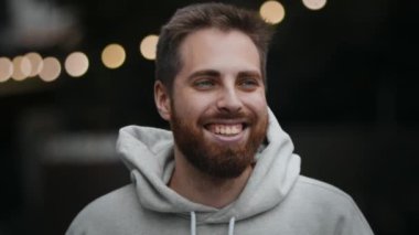 Close-up of a bearded man looking at camera and smiling, happy