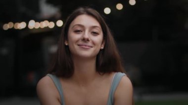 Close-up: attractive girl woman outdoors smiling looking at camera, happy