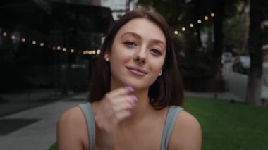 Close-up: attractive girl woman outdoors smiling looking at camera, happy