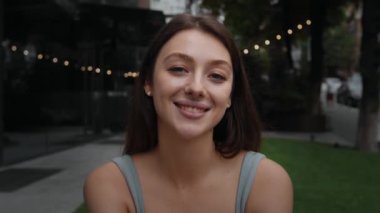 Close-up: attractive girl woman outdoors smiling looking at camera, happy