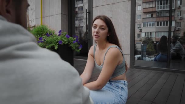 Woman Telling Gossip Friend While Sitting Outdoors — 图库视频影像