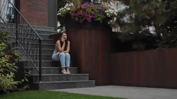 Attractive Girl Sitting House Talking Phone Modern City — Vídeos de Stock