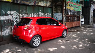 Yolun kenarına park edilmiş güzel kırmızı bir arabanın fotoğrafı. Duvar kağıdı ve sunum şablonları için uygun - jakarta 02 Temmuz 2022