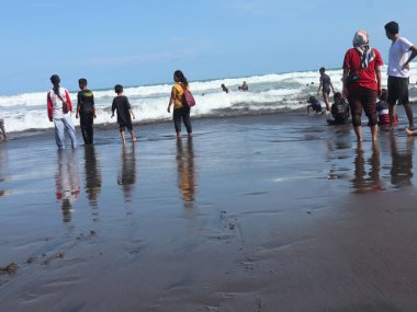 Plajın atmosferi tatil nedeniyle ziyaretçilerle doludur, insanlar seyahat etmeyi sever.