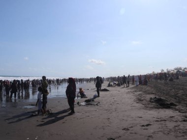 Plajın atmosferi tatil nedeniyle ziyaretçilerle doludur, insanlar seyahat etmeyi sever.