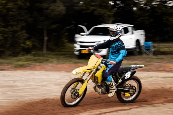 Ormandaki profesyonel motosiklet sürücüsü doğa yolundaki çamurdan geçer..