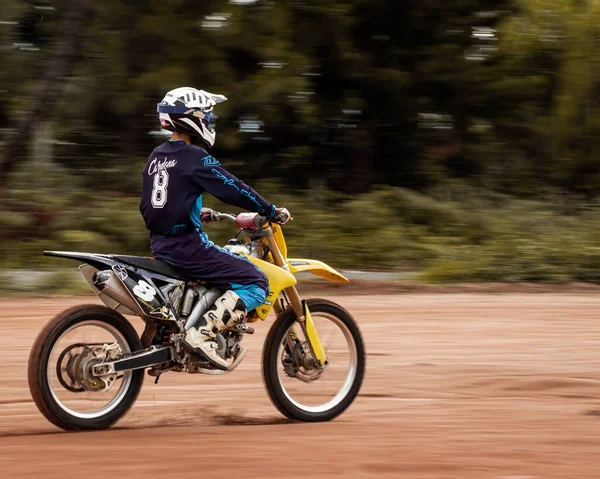 Ormandaki profesyonel motosiklet sürücüsü doğa yolundaki çamurdan geçer..