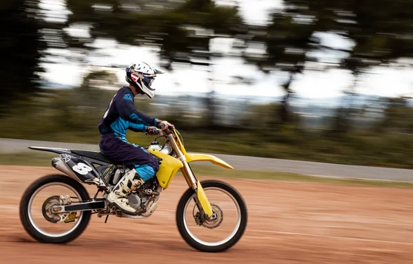 Ormandaki profesyonel motosiklet sürücüsü doğa yolundaki çamurdan geçer..