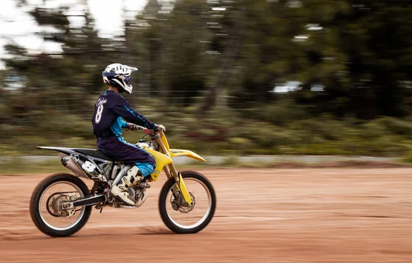 Ormandaki profesyonel motosiklet sürücüsü doğa yolundaki çamurdan geçer..