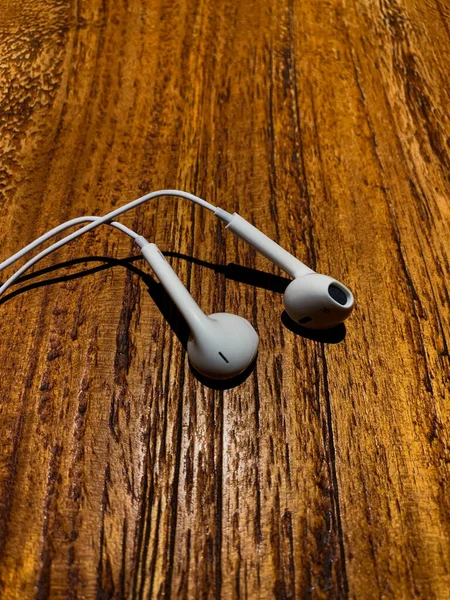 Beyaz ahşap arka planlı kulaklık.