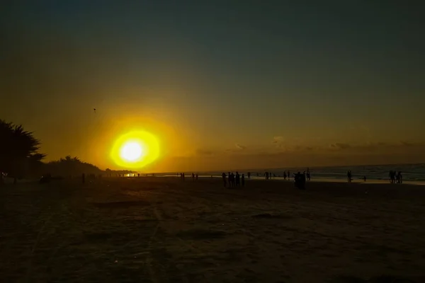 Sahilde gün batımı güzel bir siluet oluşturur.