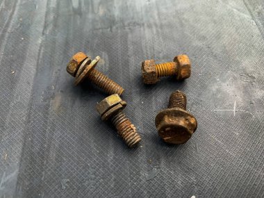 Gri arkaplandaki paslı cıvatalar