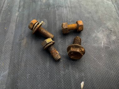 Gri arkaplandaki paslı cıvatalar