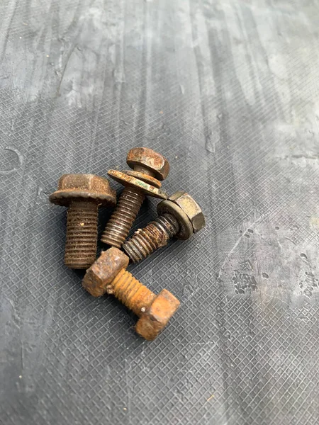 Gri arkaplandaki paslı cıvatalar