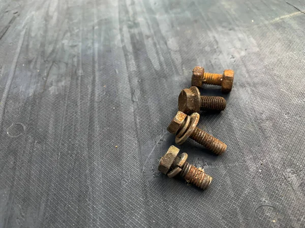 Gri arkaplandaki paslı cıvatalar