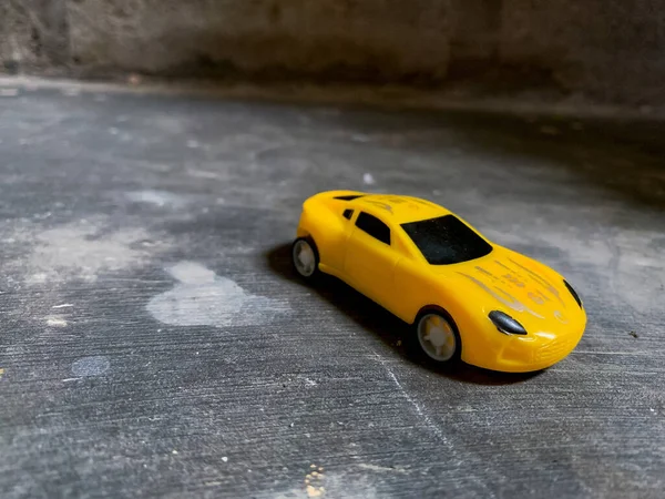 Coche Juguete Amarillo Sobre Fondo Gris Oscuro — Foto de Stock