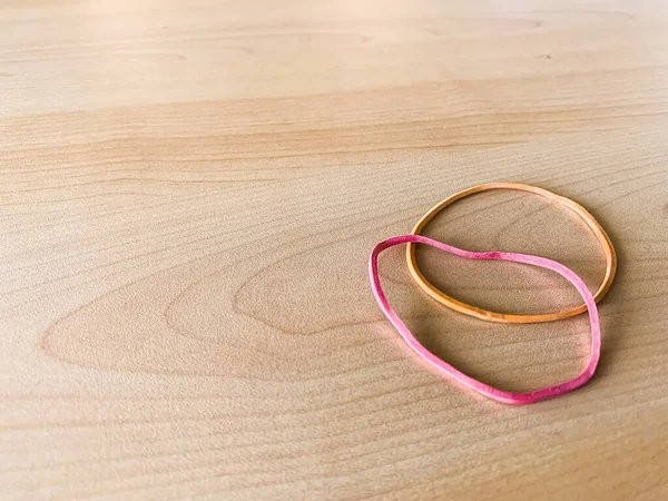 Ahşap bir masada iki lastik bant