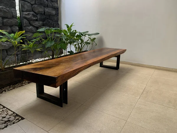 Tahtadan yapılmış uzun bir sandalye hafif açık bir odaya yerleştirilir.