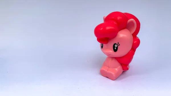 Beyaz arka planı pembe olan çocuk oyuncak midillisi.