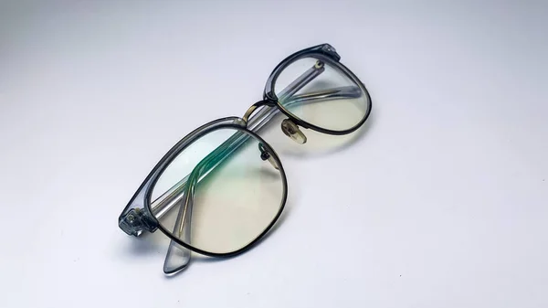 Beyaz arka planı olan açık gri gözlüklü. Bu gözlükler genellikle bilgisayarın önünde ya da sadece kitap okurken kullanılır..