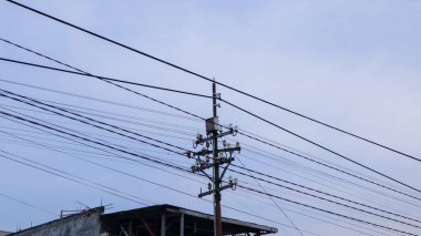 Apartman sakinlerinin evlerinin etrafında elektrik direkleri