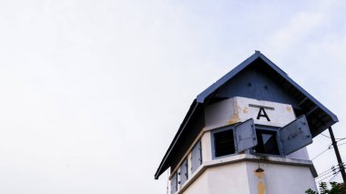 İstasyonun yakınındaki demiryolu geçidini gözetliyorum.