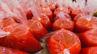 Masanın üzerinde şeffaf bir plastiğe sarılmış sos.