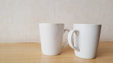 Tahta bir masada boş beyaz bir fincan.