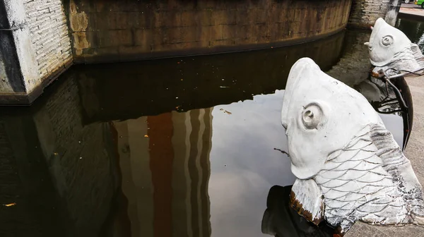 Beyaz renkli bir balık şeklinde çeşme süslemesi.