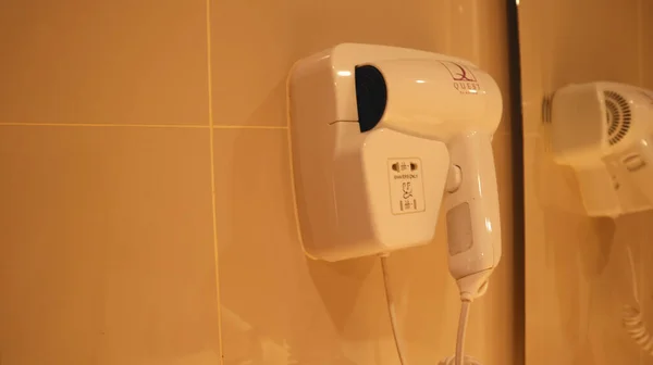 15 Nisan 2022 Surabaya, Endonezya. Banyodan sonra kullanılan beyaz saç kurutma makinesi.