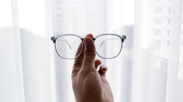 Pencere önünde bardakları tutan eller.