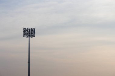 Akşam gökyüzünün arka planında stadyum ışıkları