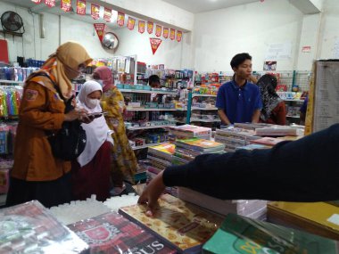 Madiun, Indonesia (8 July 2022). Bookstores are thronged by several shoppers ahead of the new school year or the start of school. Seen some parents and students are choosing the equipment to be used for school.
