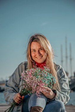 Kuru renkli çiçekleri olan bir kadın. 