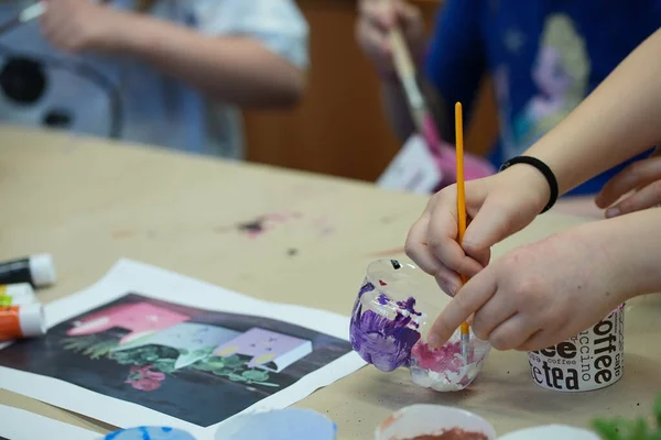 Çocuk okulda kağıda bir şeyler çiziyor.