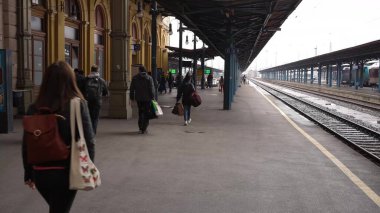 People walking at a railway station in a moody day