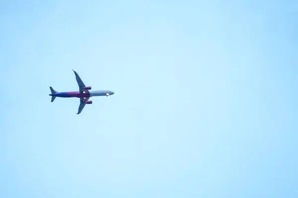 Airplane flying low below the blue sky