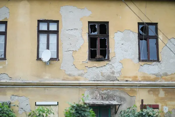 derelict house with three broken windows