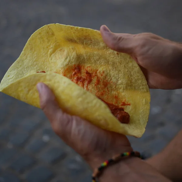 İçinde kırmızı et ve sos olan bir tortilla paketliyorum.