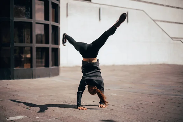 Mujer haciendo yoga avanzado al aire libre en el área urbana, vista lateral. — Foto de Stock